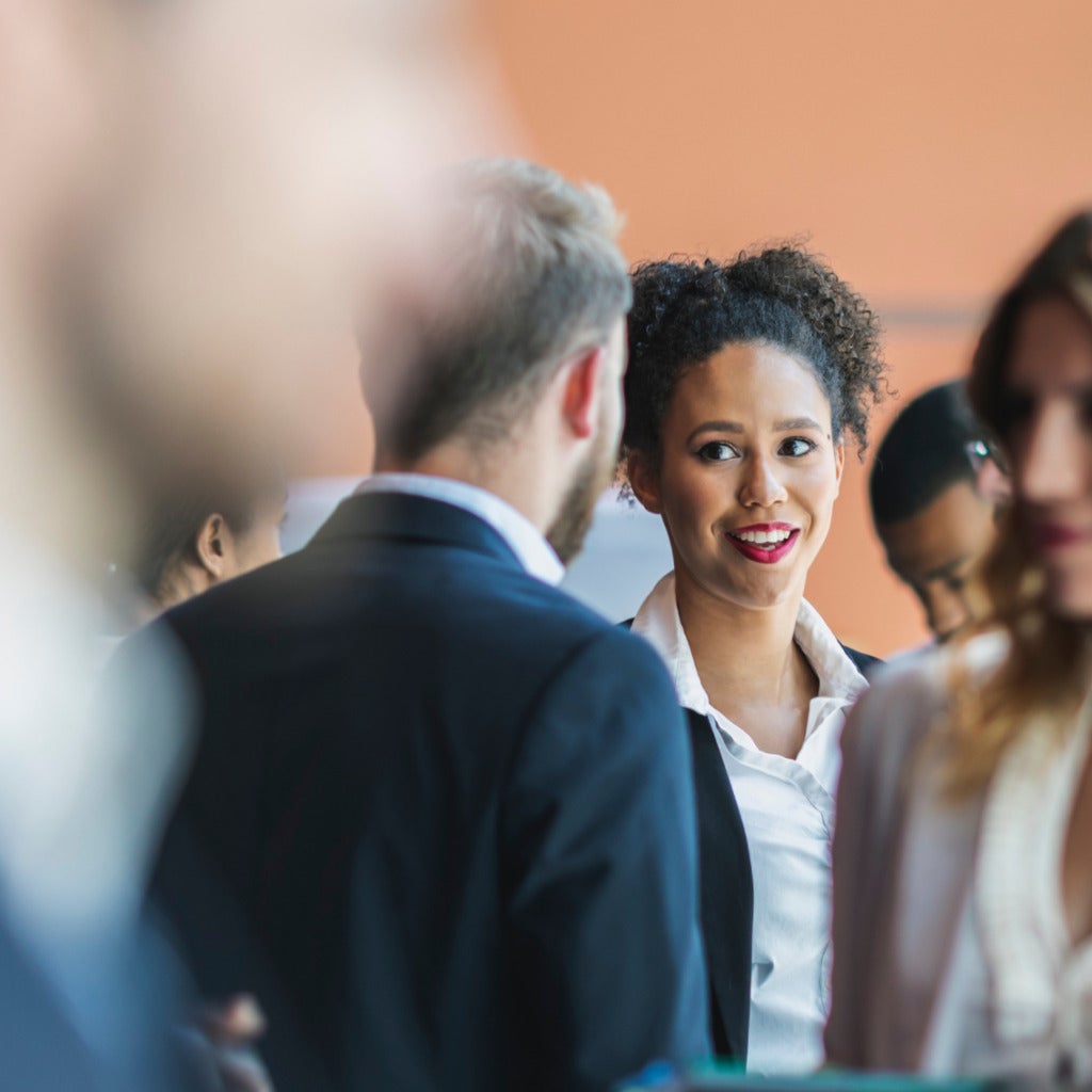 A man and woman having a conversation in the middle of a crowd.
