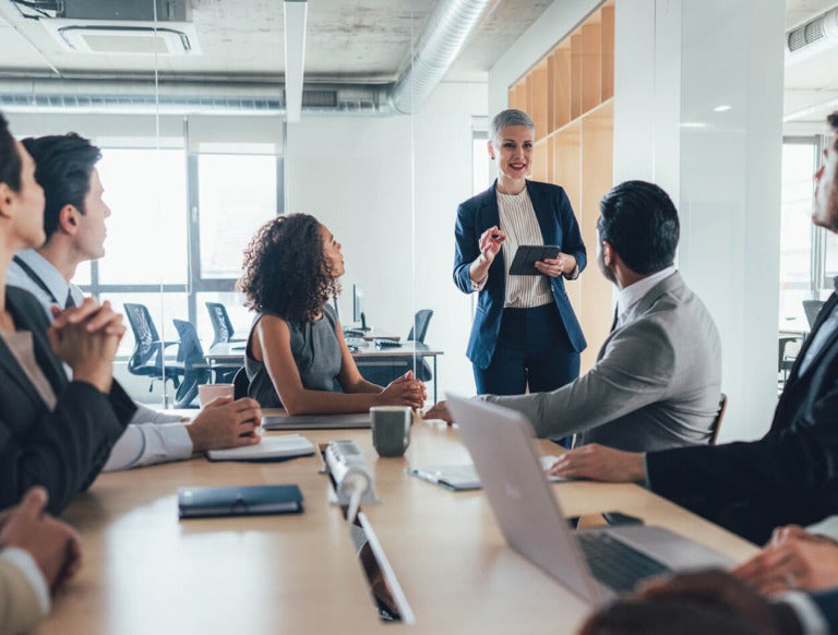 Three people having a discussion at a conference table.